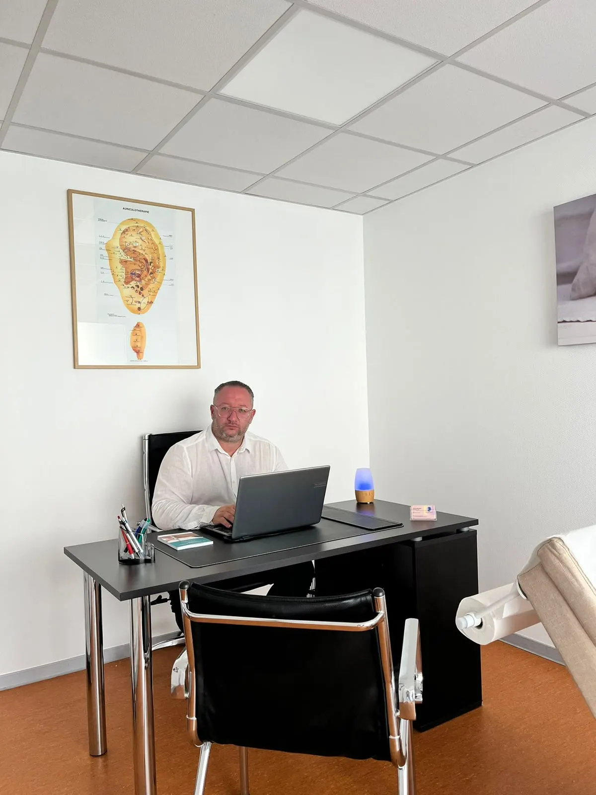 Le praticien à son bureau, au cabinet Laser center de Kingersheim